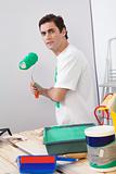Casual man holding a roller paint brush