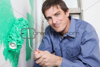 Mature man painting the wall with a roller