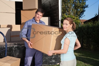 Portrait of couple carrying cardboard box