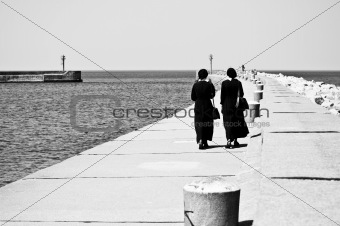 two nuns walking on seashore