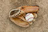 An old worn baseball in a baseball glove