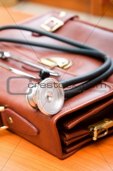 Doctor's case with stethoscope against wooden background 