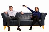 isolated couple on a couch with a gun