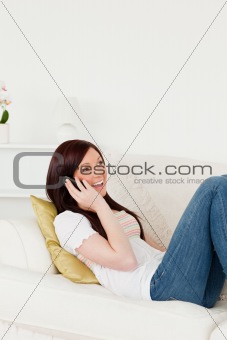 Pretty red-haired woman having a conversation on the phone while
