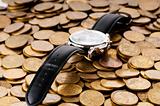 Time is money concept with watch and coins	