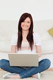 Attractive woman relaxing with her laptop while siting on a carp