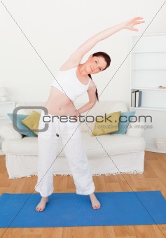 Pretty red-haired woman stretching in the living room