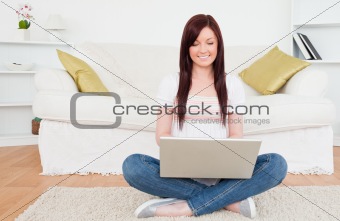 Beautiful female relaxing with her laptop while siting on a carp