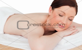 Charming pretty red-haired female relaxing in a spa centre
