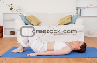 Gorgeous red-haired female stretching in the living room