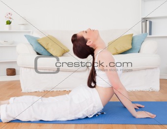 Charming red-haired female stretching in the living room