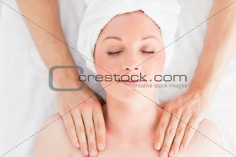 Closeup of a good looking red-haired woman receiving a massage i