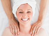 Closeup of a charming red-haired woman receiving a massage in a 