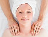 Closeup of a cute red-haired woman receiving a massage in a spa 