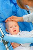 Caring mother soothing sitting in stroller crying baby
