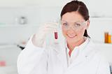 Gorgeous scientist looking at the camera while holding a  test t