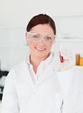Smiling scientist looking at the camera while holding a  test tu