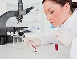 Cute red-haired female scientist doing an experiment in a lab