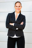 Smiling business woman with crossed arms on chest standing at office building

