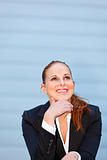 Smiling business woman at office building  looking up at copy-space
