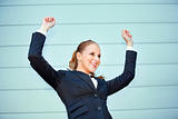 Excited  business woman standing at office building  success 
