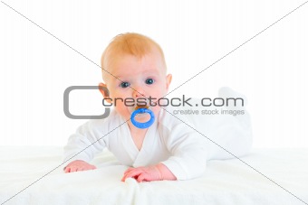 Sweet  four month old  baby with soother laying on diaper
