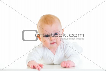Smiling four month old  baby laying on abdomen
