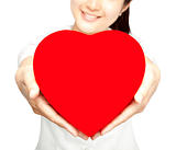Smiling girl holding red heart symbol