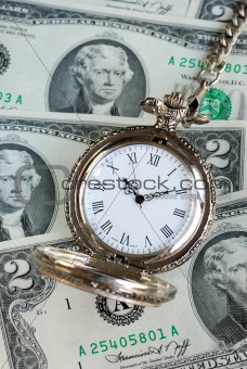 Old pocket watch on a stack of $2 bills -- Time is money