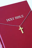 A golden cross on the top of a red bible