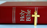 A golden cross next to the red bible