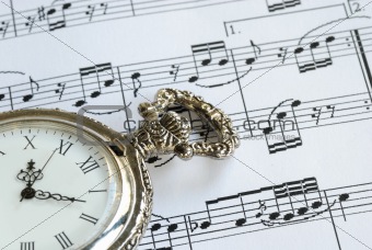 Antique pocket watch on the music sheet