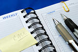 Write some notes on the day planner isolated on blue