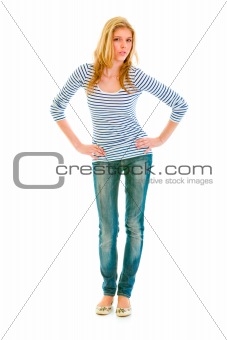 Full length portrait of beautiful teen girl with hands on hips attentively looking at you
