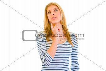 Thoughtful beautiful teen girl with hand near face looking up at copy-space
