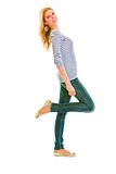 Full length portrait of smiling beautiful teen girl standing on one leg
