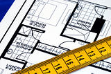 Measure the floorplan with a  measuring tape isolated on blue