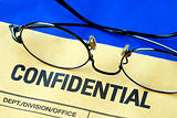 Glasses on the confidential envelope isolated on blue