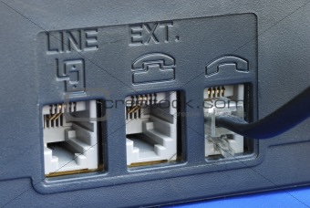 Line connectors at the back of a fax machine isolated on blue