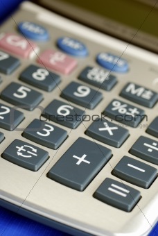 Close up view of a calculator isolated on blue