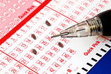 Filing the lottery ticket with a pencil isolated on blue