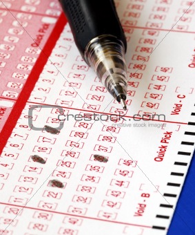 Filing the lottery ticket with a pencil isolated on blue