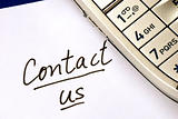 The words Contact us with a cellular phone words We Can Help on a white paper