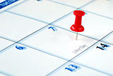 A red pin nailed in the business calendar