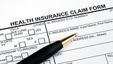 Filling the health insurance claim form with a pen