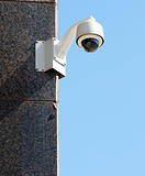 Security / surveillance camera against a clear blue sky