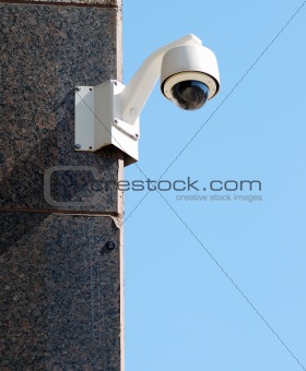 Security / surveillance camera against a clear blue sky