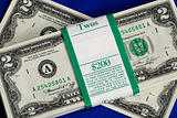 Piles of United States two dollar bills isolated on blue