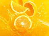 Fresh oranges falling in juice