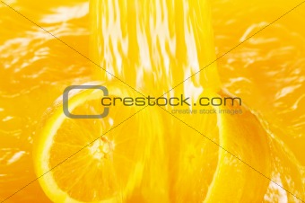 Fresh oranges falling in juice